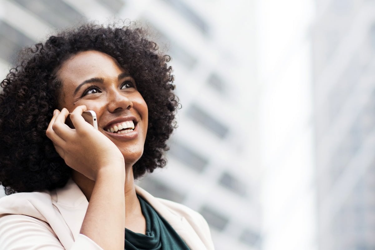 smiling female talking on the phone in the city