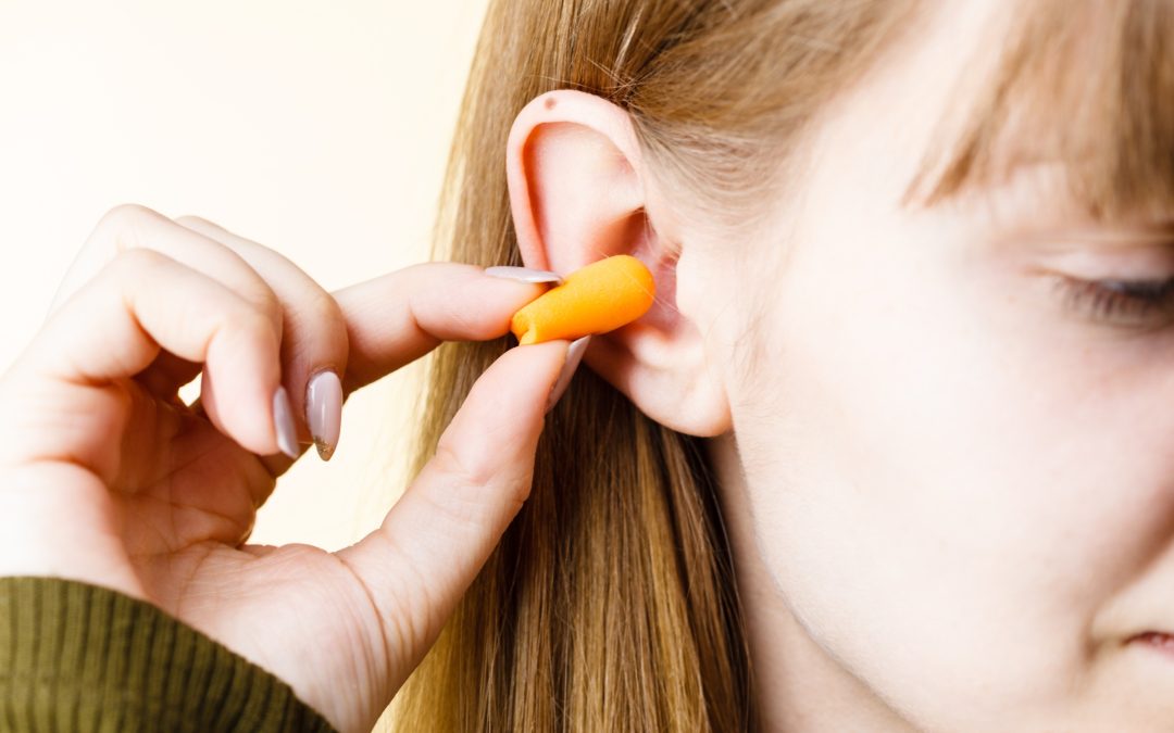 Woman putting earplugs in her ear